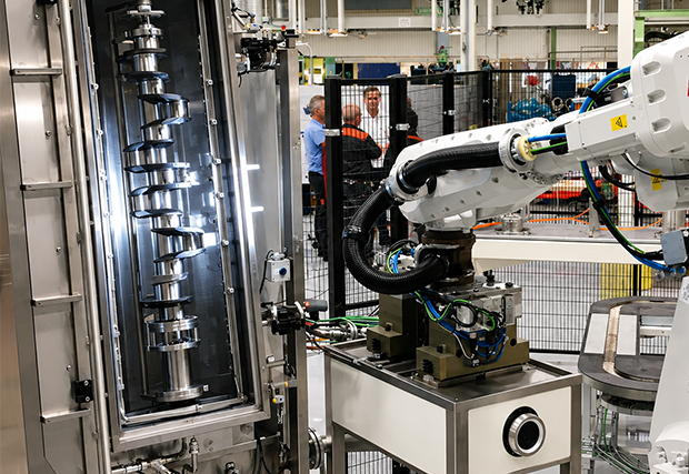 Cigüeñal cargado verticalmente por un robot en una máquina de limpieza de piezas - MecanoFAST